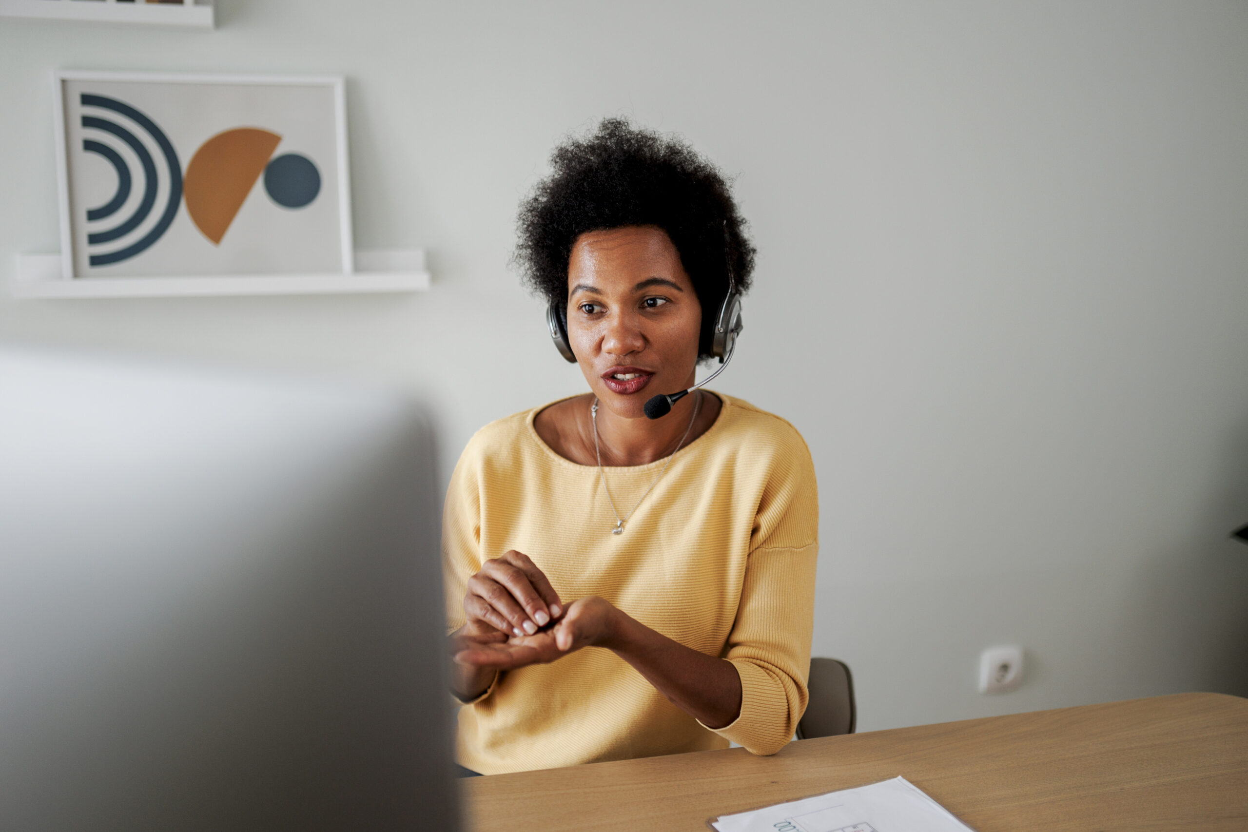 Mid adult female call center agent working at her desk in the office